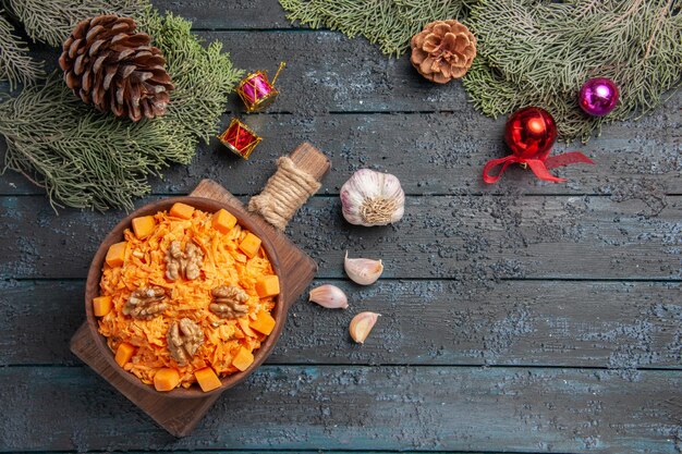 Draufsicht geriebener Karottensalat mit Walnüssen auf dunkelblauem Hintergrund Naturkostsalat Farbe Diät Nuss