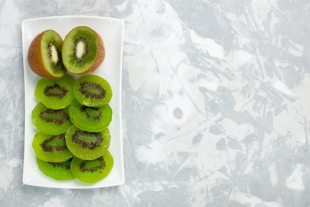 Draufsicht geschnittene frische Kiwis innerhalb Platte auf weißem Hintergrund