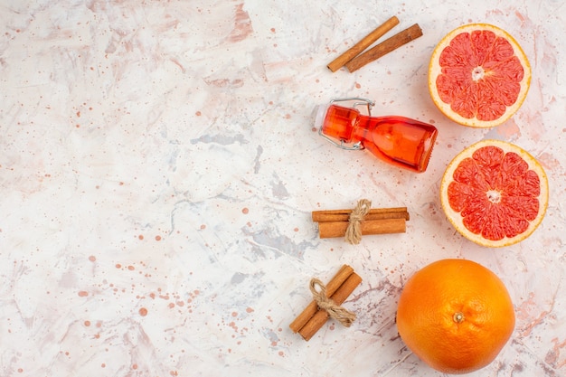 Draufsicht geschnittene Grapefruits-Grapefruit-Zimtstangenflasche auf nackter Oberfläche mit Kopierplatz