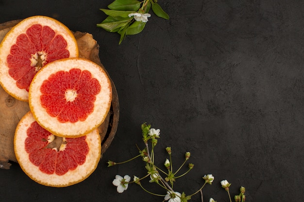 Draufsicht geschnittene Grapefruits Ringe weich saftig auf dem dunklen Hintergrund