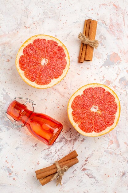 Draufsicht geschnittene Grapefruits-Zimtstangenflasche auf nackter Oberfläche