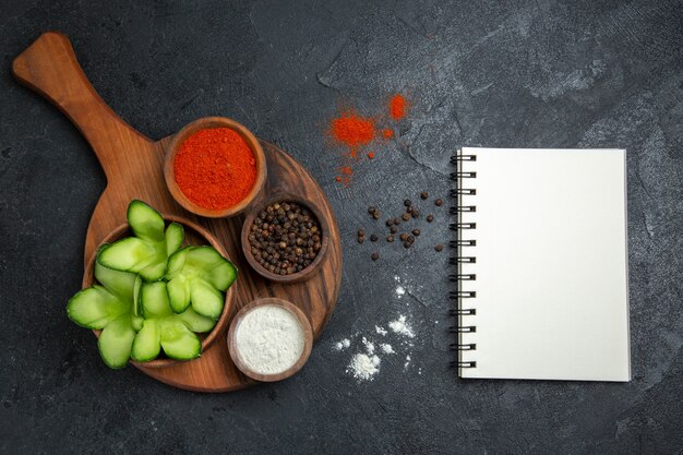 Draufsicht geschnittene Gurken mit Gewürzen auf dem grauen Hintergrundsalatgesundheitsgemüsemahlzeitnahrung