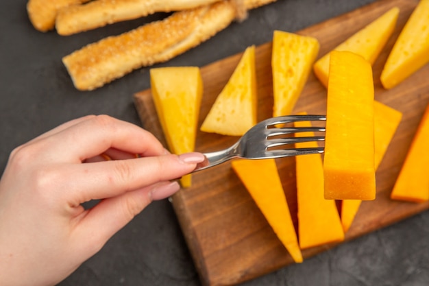 Draufsicht geschnittener Frischkäse mit Brötchen auf dunklem Hintergrund