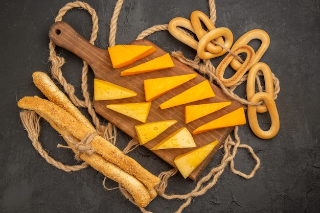 Draufsicht geschnittener Frischkäse mit Seilen auf dunklem Hintergrund