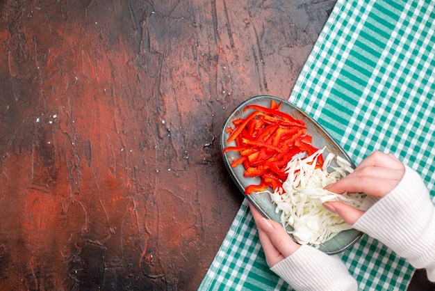 Draufsicht geschnittener Kohl mit Paprika auf dunklem Tisch