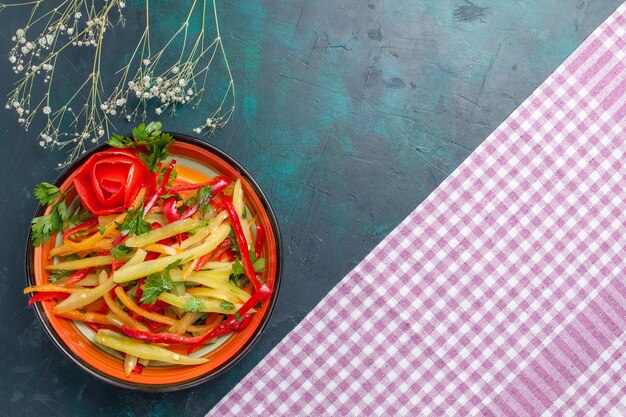 Draufsicht geschnittener Paprika farbiger würziger Salat auf dem dunkelblauen Schreibtisch