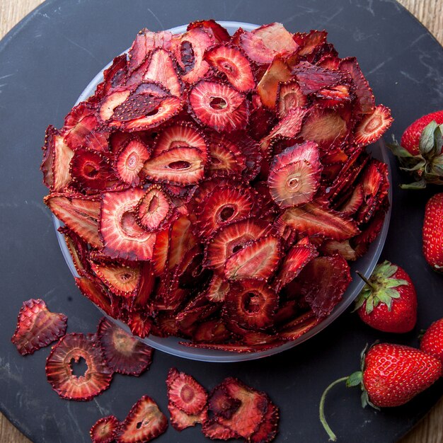 Draufsicht getrocknete Erdbeere im Teller auf rundem Tablett
