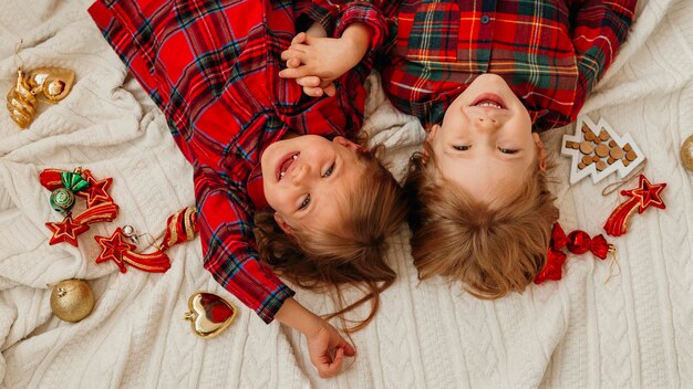 Draufsicht glückliche Kinder, die Spaß im Bett an Weihnachten haben