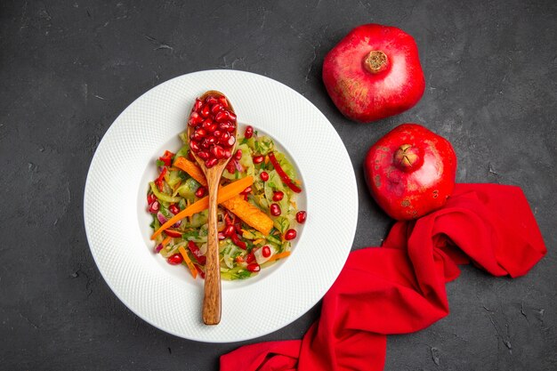 Draufsicht Granatapfel Gemüsesalat rote Tischdecke Granatäpfel