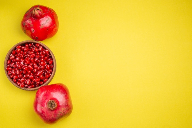 Draufsicht Granatapfel zwei Granatäpfel und Kerne des appetitlichen Granatapfels in Schüssel