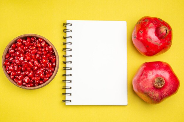 Draufsicht Granatapfel zwei Granatäpfel weiße Notizbuchschale mit Samen des appetitlichen Granatapfels