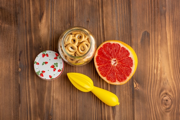 Draufsicht Grapefruit und Cracker auf dem braunen Schreibtisch