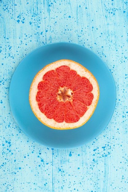 Draufsicht Grapefruitring rund saftig weich in blauen Platte auf dem hellblauen Boden