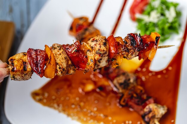 Draufsicht Hähnchen-Spieße Gegrilltes Hähnchenfilet mit roter und gelber Paprika-Gewürzsauce und Sesam auf einem Teller