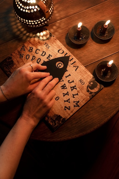 Draufsicht Hände auf Ouija-Brett