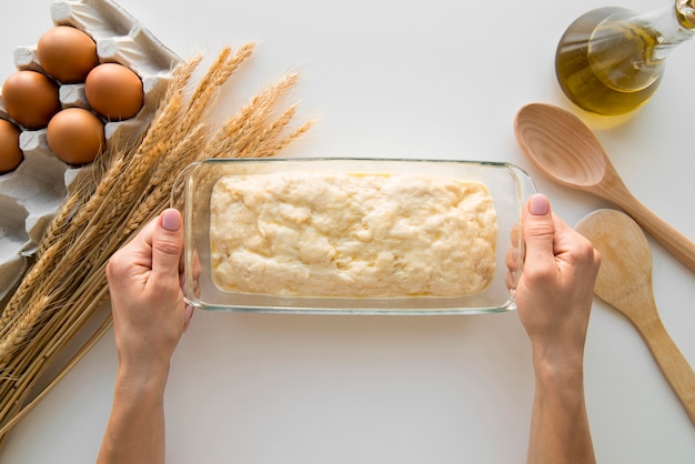 Kostenloses Foto draufsicht hände, die kuchenform mit teig halten