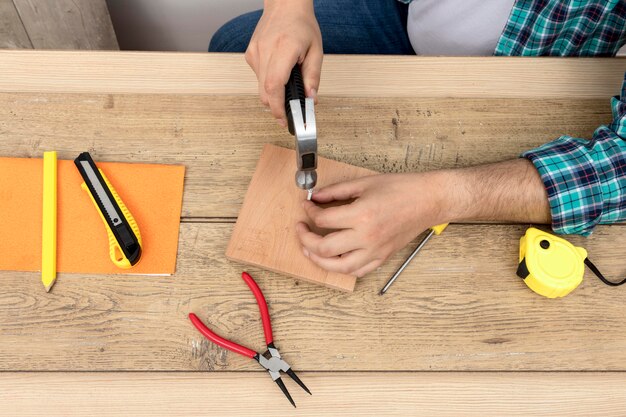 Draufsicht Hände mit Hammer und Nägeln