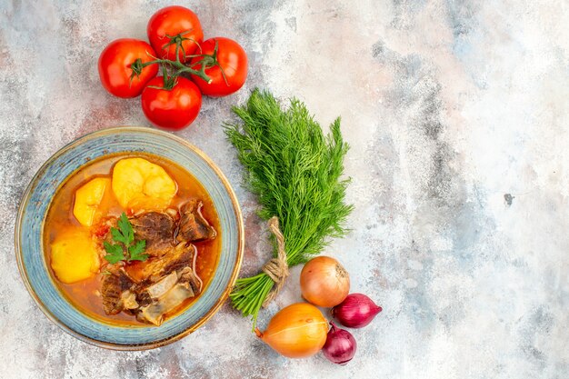 Draufsicht hausgemachte Bozbash-Suppe ein Bündel Dill-Tomaten-Zwiebeln auf nackter Oberfläche