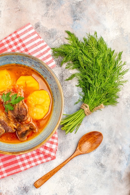 Draufsicht hausgemachte Bozbash-Suppe Küchentuch ein Bündel Dillholzlöffel auf nacktem Hintergrund