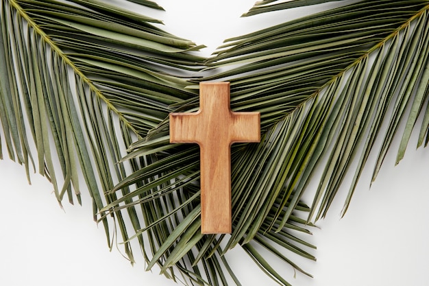 Draufsicht Holzkreuz auf Blättern