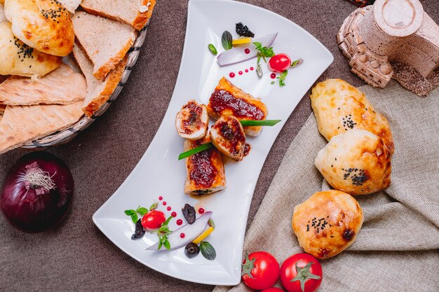 Draufsicht Hühnerbrustrolle mit Soßentomaten und Brot