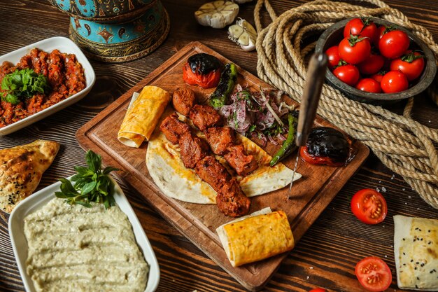 Draufsicht Hühnerkebab mit gegrillter Tomate und Paprika auf Fladenbrot auf einem Ständer