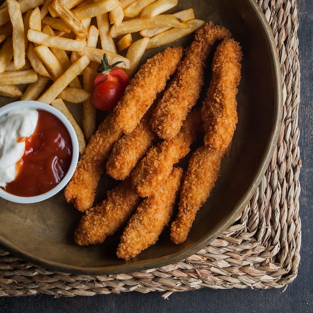 Draufsicht Hühnernuggets mit Pommes Frites und Sous und Tomate in Tonschalen