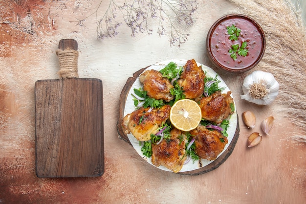 Draufsicht Huhn Huhn mit Kräutern Zitronen-Knoblauch-Sauce neben dem Schneidebrett