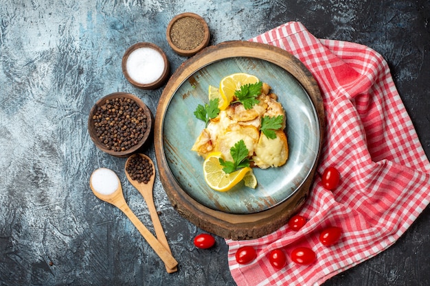 Draufsicht Huhn mit Käse auf Teller auf Holzbrettgewürzen in Schalen auf grauem Tisch