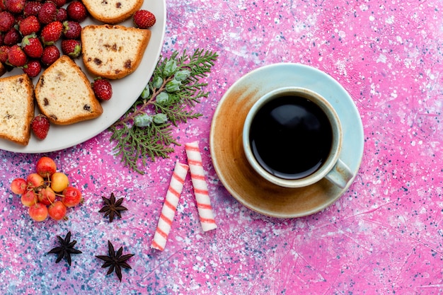 Kostenloses Foto draufsicht in scheiben geschnitten leckere kuchen mit frischen roten erdbeeren und tasse kaffee auf rosa schreibtisch