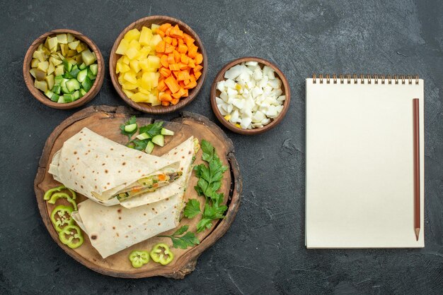 Draufsicht in Scheiben geschnitten leckeres Shaurma-Salat-Sandwich auf der grauen Oberfläche Pita-Mahlzeit-Salat-Burger-Sandwich