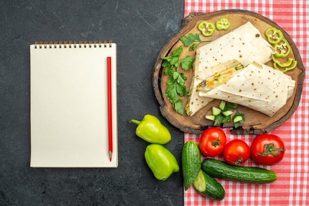 Draufsicht in Scheiben geschnittenes köstliches Shaurma-Salat-Sandwich mit frischem Gemüse auf dem grauen Oberflächenmahlzeit-Pita-Salat-Sandwich-Burger