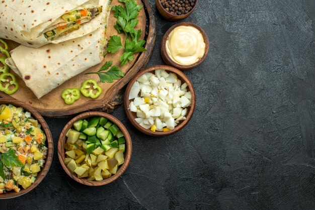 Draufsicht in Scheiben geschnittenes köstliches Shaurma-Salat-Sandwich mit frischem Gemüse auf dem grauen Oberflächenmahlzeit-Pita-Salat-Sandwich-Burger