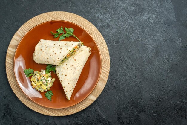 Draufsicht in Scheiben geschnittenes shaurma leckeres Fleisch- und Salatsandwich auf der grauen Oberfläche