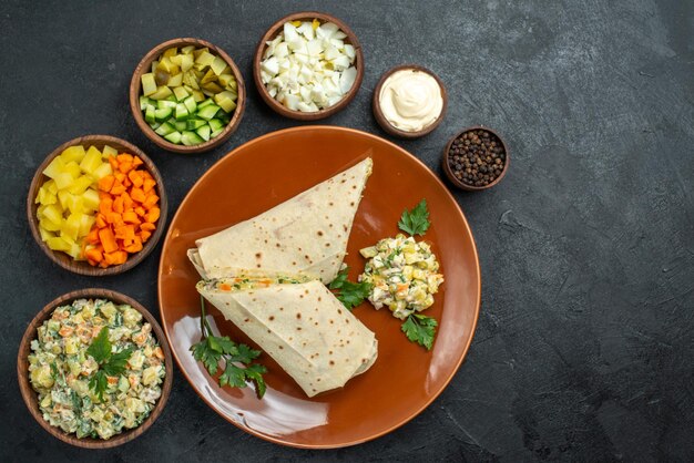 Draufsicht in Scheiben geschnittenes shaurma leckeres Fleischsandwich mit Salatzutaten auf der dunklen Oberfläche Burger-Sandwich-Brot-Pita-Fleisch