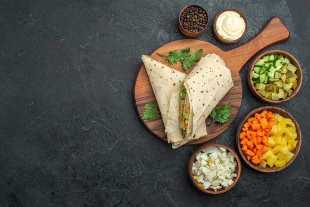 Draufsicht in Scheiben geschnittenes Shaurma leckeres Salatsandwich mit Gemüse auf der grauen Oberfläche Burger Pita Sandwich Salatbrot