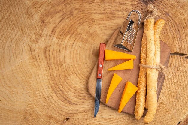 Draufsicht Käse- und Brotmesser kleine Reibe auf Schneidebrett