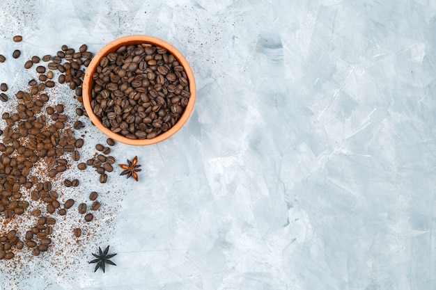 Draufsicht-Kaffeebohnen in einer Schüssel mit Gewürzen auf Schmutzhintergrund