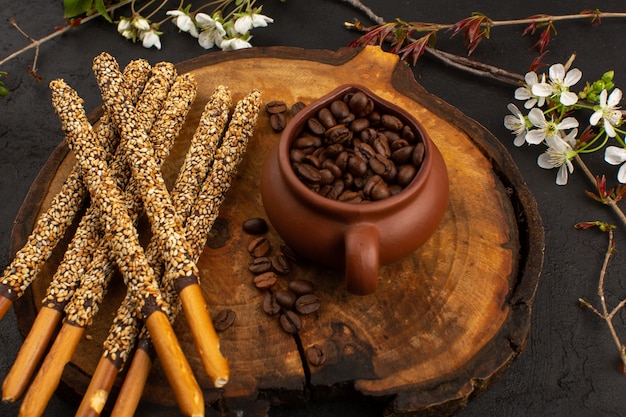 Draufsicht Kaffeesamen braun zusammen mit Zuckerstangen auf dem grauen Boden