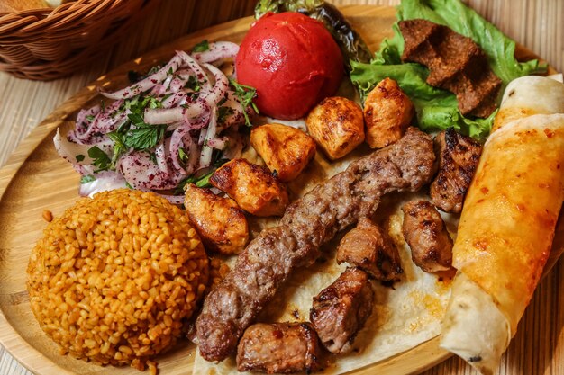 Draufsicht Kebab Mix mit Bulgur Zwiebel und Fladenbrot mit Gemüse auf einem Ständer