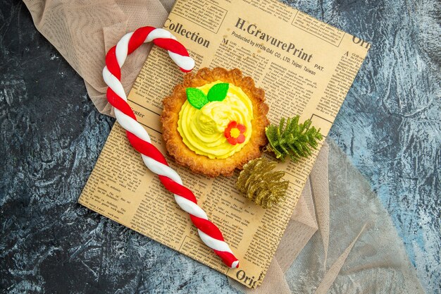 Draufsicht Keks mit Weihnachtsschmuck auf Zeitung auf dunklem Hintergrund