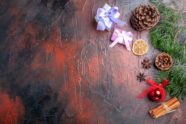 Draufsicht Kiefernzweig mit Zapfen Anis Zimt Weihnachtsdetails auf dunkelrotem Hintergrund freier Platz Weihnachtsfoto