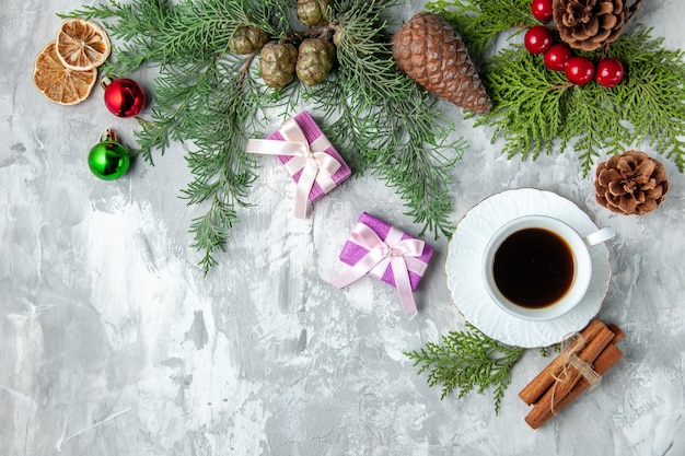 Draufsicht Kieferzweige kleine Geschenke Weihnachtsbaum Spielzeug Zimtstangen auf grauem Hintergrund