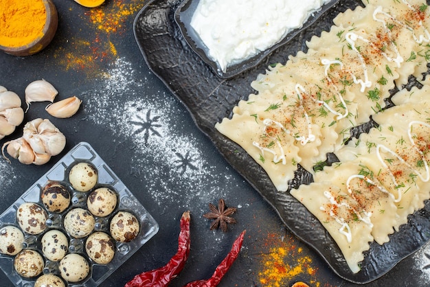 Kostenloses Foto draufsicht kleine gekochte knödel mit verschiedenen zutaten auf dem dunklen hintergrund gemüsegericht abendessen kochen mahlzeit farbteig