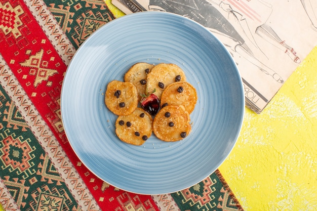 Draufsicht kleine Keksgebäck innerhalb der blauen Platte auf gelbem Tisch, backen Sie süßes Teegebäck