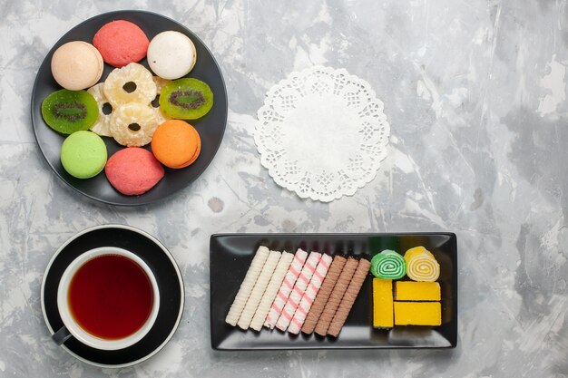 Draufsicht kleine Kuchen mit Kekstasse Tee und Kekse auf weißem Backgruond-Kekskeks süßer Zuckertorten-Tee