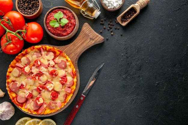 Draufsicht kleine leckere Pizza mit frischen roten Tomaten auf dem dunklen Tisch Lieferfreiraum