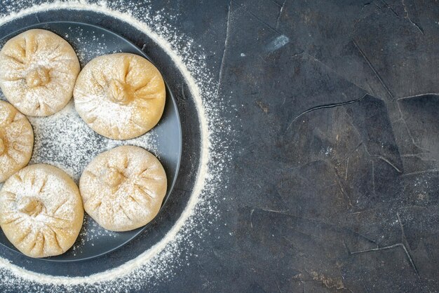 Draufsicht kleine rohe Knödel auf grauem Hintergrund Farbe Lebensmittelkuchen Mehl backen Fleischteig Ei leckeren freien Platz für Text