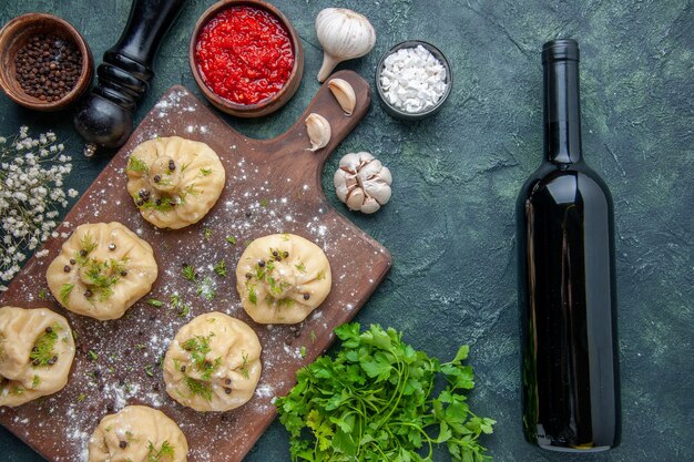 Draufsicht kleine rohe Knödel mit Tomatensauce auf dunkelblauem Hintergrund, der Abendessen Teig Weingericht Mahlzeit Küche Fleisch kocht