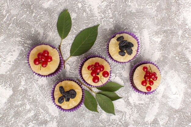 Draufsicht kleine Schokoladenbrownies mit Preiselbeeren auf dem hellen Hintergrundkuchen-Kekszucker-süßen Backteig